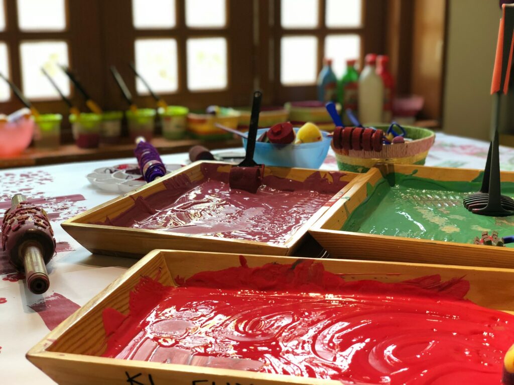 Photo by Gautam Arora assorted paints in brown wooden trays on table
